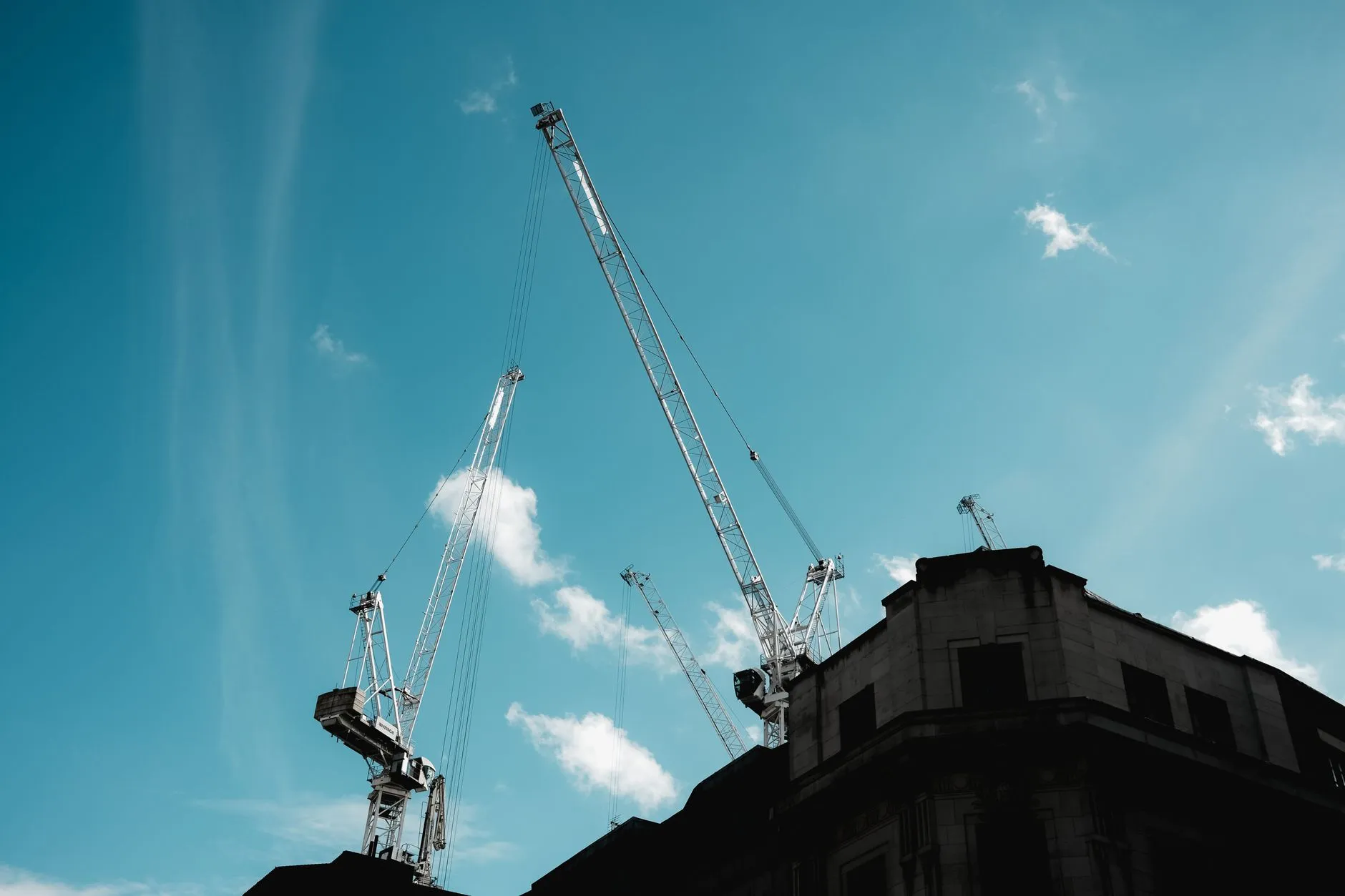 Construction cranes against a blue sky