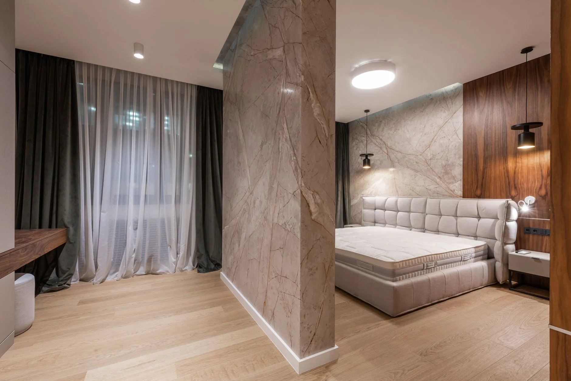 Apartment interior with a bed near curtained windows